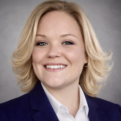 Smiling blonde woman in navy blazer professional headshot