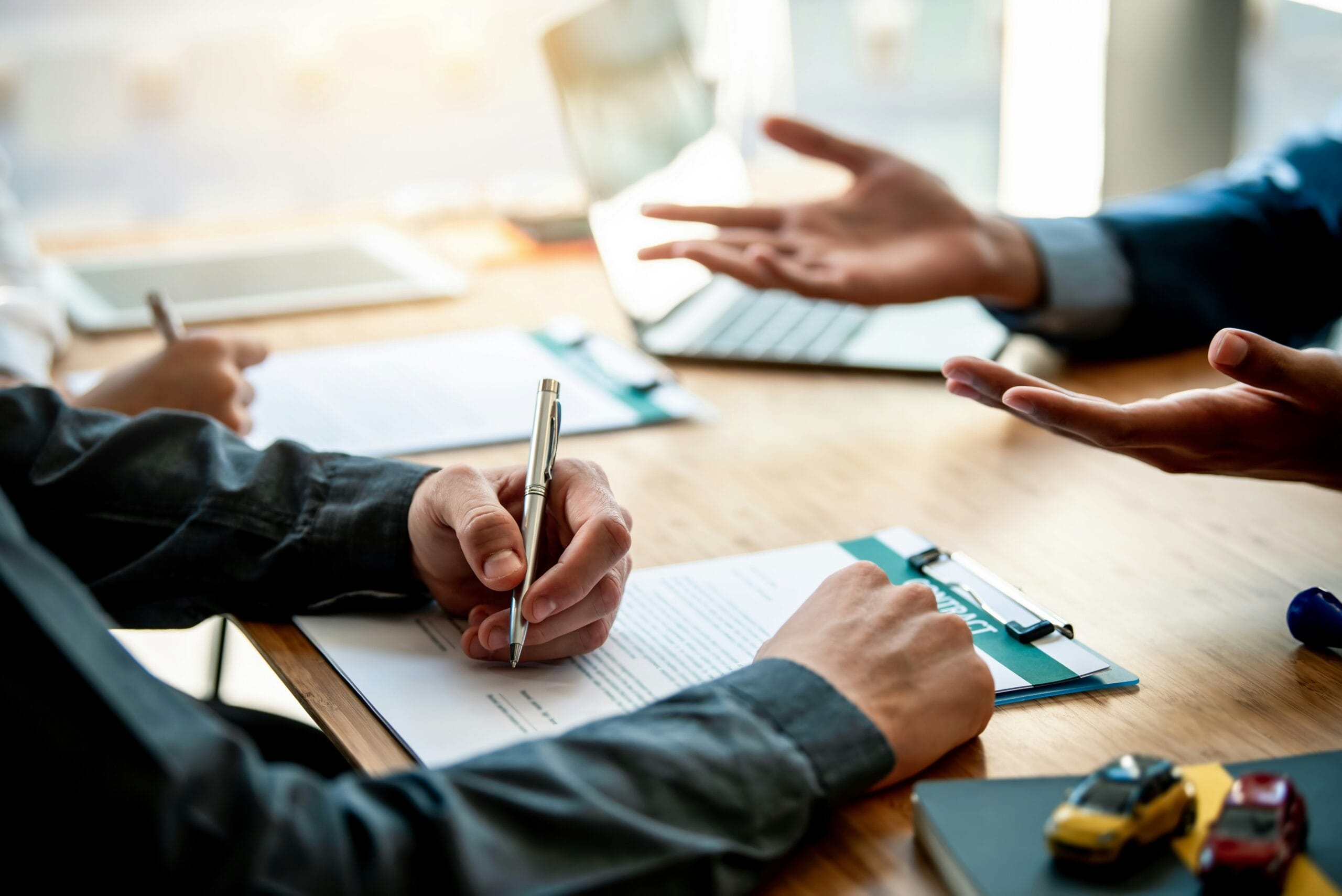 Two people signing contract at desk