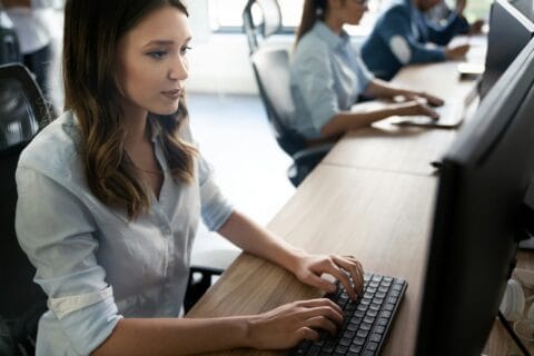 Office workers typing on desktop computers