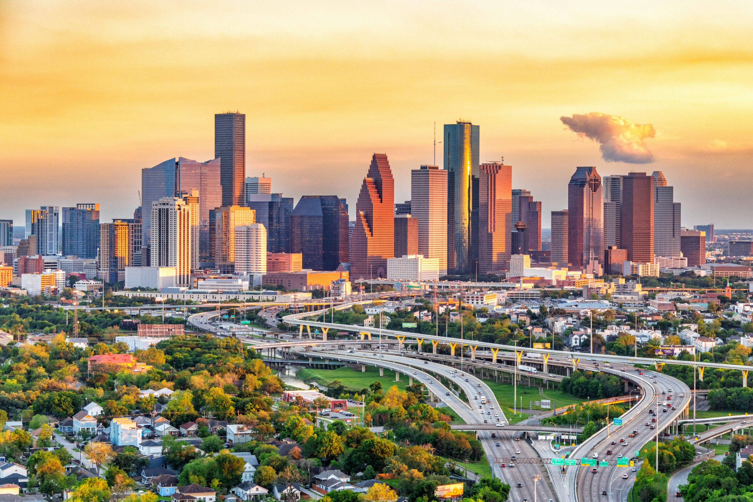 Houston skyline and freeway interchange glowing at sunset