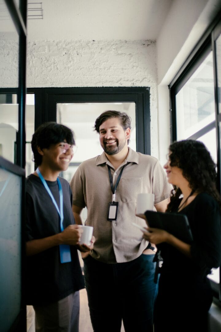 Coworkers chatting and smiling in office hallway
