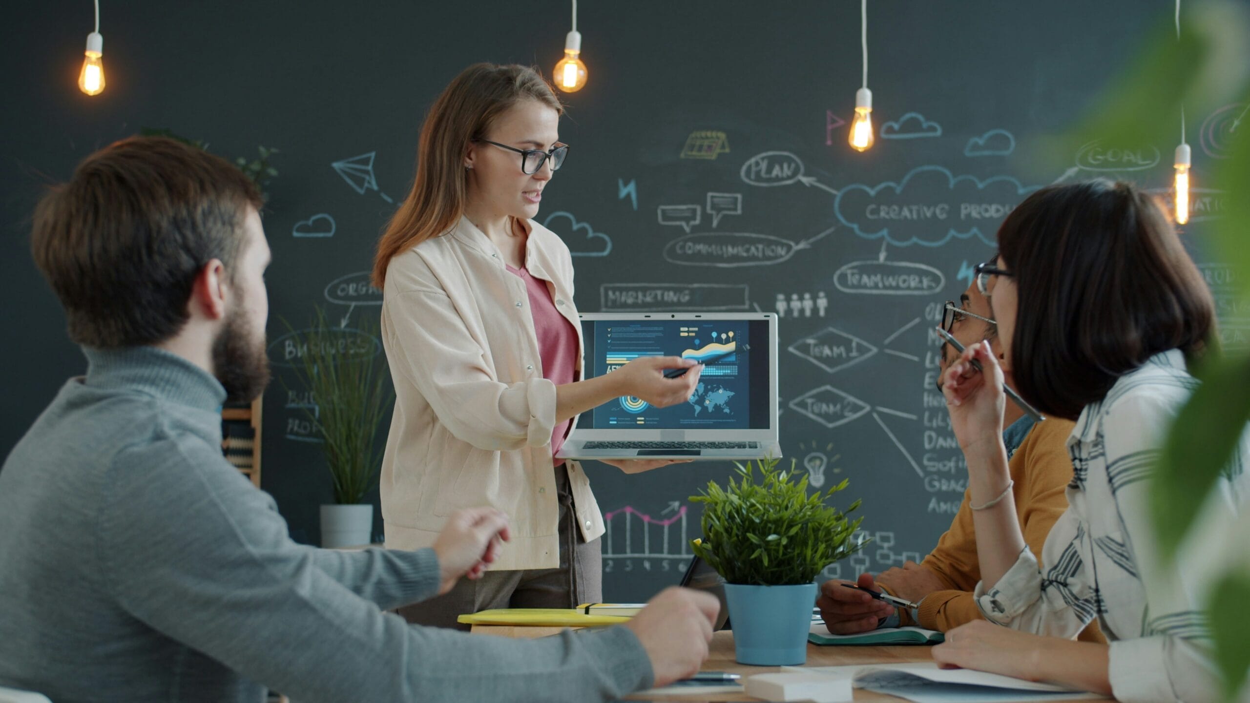 Woman presenting marketing data to team in office